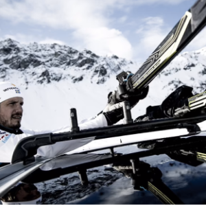 Skier putting skis on top of car