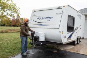 person putting towing accessory on camper