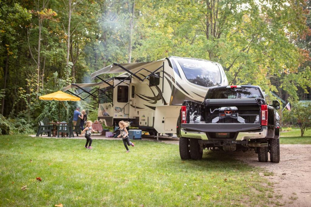 truck and camper on campground with family